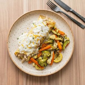 Panqueca Low carb recheada de frango cremoso ao molho branco e raspas de laranja. Acompanha mix de legumes